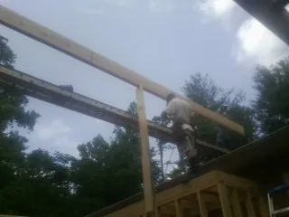 Carpenter setting a ridge beam over a new addition frame — Ice Dam Removal by Roofing Brothers in Worden