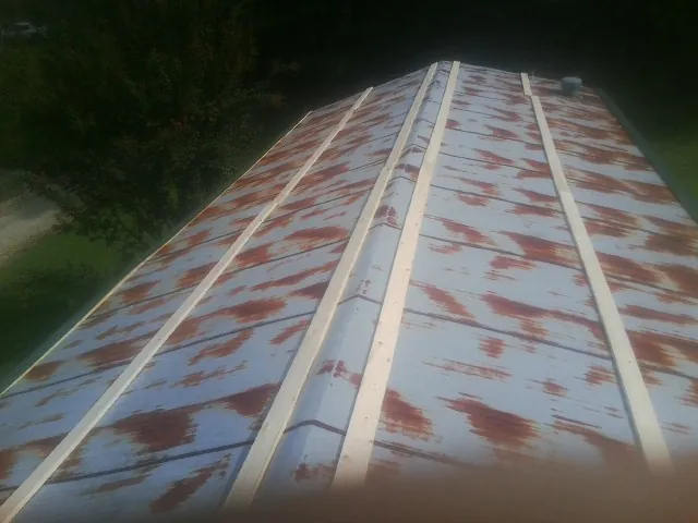 Rusted metal roof panels with new wood purlins before replacement — Storm Damage Roof Repair in Worden by Roofing Brothers