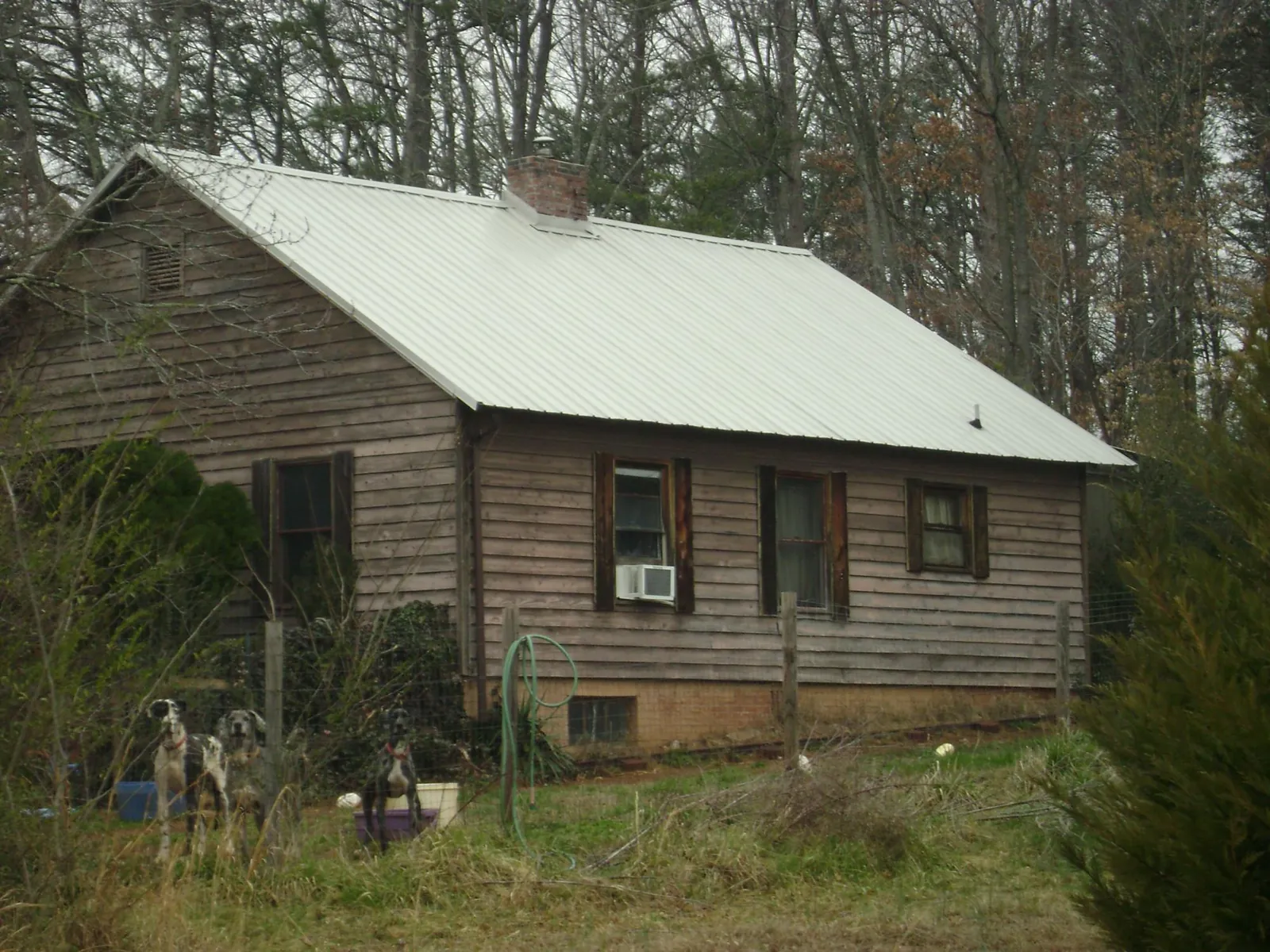 White metal roof on an old wood sided farmhouse, from a Metal Roof Installation job in Worden